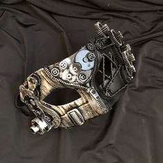 Upgrade your Steampunk costume with this awesome mask. This Steampunk mask is painted silver/black abstract design and accented with lots of gears and detail. Mask is light weight, durable, and comes with a 1/2 " thick elastic band for a secure fit. Steampunk mask size 7"W x 3.5"H. Mask style Steampunk. Adjustable Masks And Prosthetics For Carnival And Halloween, Steampunk Masks And Prosthetics For Carnival Costume Party, Punk Style Eye Mask For Costume Party, Adjustable Masks And Prosthetics For Halloween Carnival, Punk Style Masquerade Mask For Costume Party, Black Steampunk Masks For Costume Party, Steampunk Masks And Prosthetics For Costume Party, Punk Masquerade Mask For Costume Party, Punk Masks And Prosthetics For Carnival Costume Party