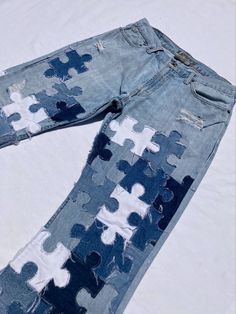 an old pair of jeans that has been painted with puzzle pieces on the bottom and sides