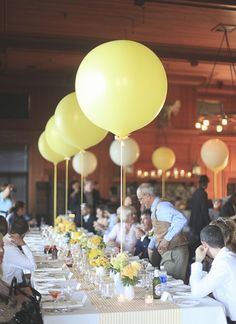 a table filled with lots of yellow balloons