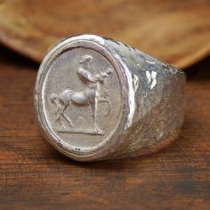 Centaur Coin Ring is a ring design that symbolizes the unique creature, Centaur, which has been present in mythology for centuries. Centaur is a creature with a human upper body and a horse lower body, and in ancient Greek mythology, it was considered as the protector of forests. According to legend, the Centaurs were born from the union of the cloud nymph Nephele and the lap of the wise Centaurus. The Centaur is often depicted as a symbol of wisdom, strength, and balance, as it represents the combination of human intelligence and animal instinct. The Centaur Coin Ring captures the essence of this mythological creature, making it a meaningful and powerful accessory for those who appreciate the beauty and significance of ancient myths. Thank You for Reading, My Name Is Sultan. I Completed M Ancient Style Silver Ring For Gift, Ancient Style Engraved Silver Rings, Silver Engraved Rings In Antique Style, Silver Engraved Rings In Vintage Style, Collectible Symbolic Sterling Silver Signet Ring, Jewelry Education, Bee Jewelry, Roman Art, Bronze Ring