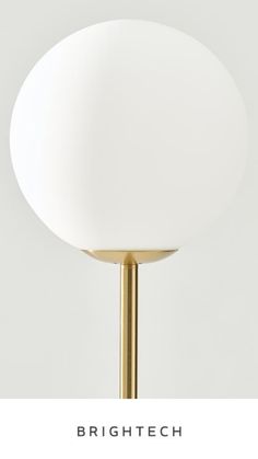 the bright tech table lamp has a white ball on it's base and is brass