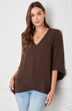 An elegant top of silky, lightweight crepe delivers elegant movement with its angled flare sleeves and fluttery asymmetrical hemline that dips low in back. 25 1/2" length (size Medium) V-neck Three-quarter sleeves Back yoke with gathering Crossover high/low hem 100% polyester Dry clean or hand wash, line dry Made in the USA of imported fabric Women's Clothing Elegant Asymmetrical Solid Blouse, Chic Viscose Top With Asymmetrical Hem, Chic Viscose Tops With Asymmetrical Hem, Chic Flowy Blouse With Asymmetrical Hem, Solid Asymmetrical Hem Blouse For Layering, Chic High-low Hem Tops For Layering, Chic Asymmetrical Drapey Tops, Elegant Asymmetrical Drapey Tops, Elegant Flowy Rayon Tops