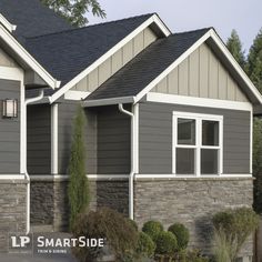 two houses with gray siding and white trim on the windows, one has a black roof