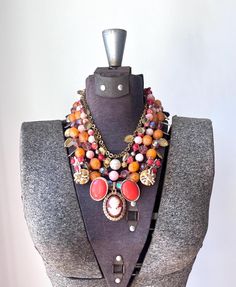 How stunning is this bright jewel tone piece? As we head into fall, I am still focused on incorporating as much color as possible into my style of work.  You can never go wrong with orange or cameos during the fall!  I have had these bright vintage orange beads for over 10 years and I finally found use for them in this stunning ensemble!  At the bottom is a repurposed vintage cameo in immaculate condition with bright red orange and dark yellow vintage earrings.  The strands are composed of big c Vintage Multicolor Jeweled Necklaces, Luxury Bohemian Orange Necklace, Vintage Orange Necklace With Large Beads, Vintage Orange Metal Necklaces, Unique Red Necklace With Large Beads, Vintage Red Necklace With Large Beads, Art Deco Boho, Orange Necklace, Vintage Cameo