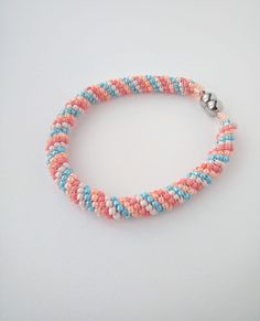 the beaded bracelet is made with multicolored seed beads and silver clasps