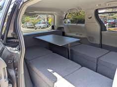 the interior of a van with two seats and a table in the passenger side area