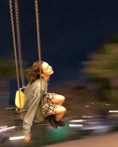 a woman sitting on a swing at night