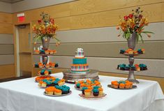 three tiered cakes and cupcakes on a table