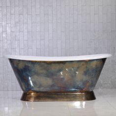 a bath tub sitting on top of a white tile floor next to a tiled wall