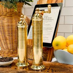 two golden salt and pepper shakers sitting on a wooden table next to some lemons