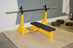 a bench with two squats on it in front of a gray wall and other equipment