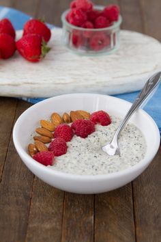 a bowl of yogurt with raspberries and almonds on the side