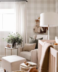 a living room filled with furniture and a baby's crib next to a window