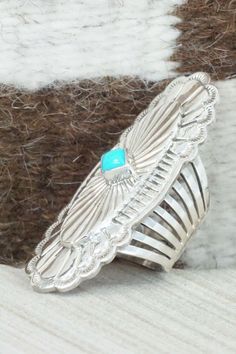 This vintage turquoise and sterling silver ring was made by Navajo silversmith Mike Smith. The back of the ring is signed RB and stamped sterling. Please note this is a pre-owned piece, with patina, in vintage condition.Size: 6.5Length: 2 1/4"Width: 3/4"Free shipping on all orders! We ship with USPS and always include tracking. All orders ship within a day of payment.Returns are accepted up to 30 days after you receive your order. Just send us a message. Our shop offers cash back or store credit Western Sterling Silver Turquoise Ring With Patina, Handmade Silver Turquoise Ring In Western Style, Handmade Western Style Silver Turquoise Ring, Western Silver Turquoise Ring Stamped 925, Artisan Silver Turquoise Ring With Concho, Antique Silver Turquoise Ring With Patina, Unique Silver Turquoise Concho Ring, Southwestern Silver Turquoise Ring With Concho, Mike Smith