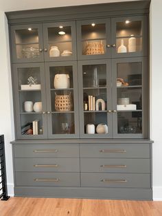 a large gray china cabinet with glass doors