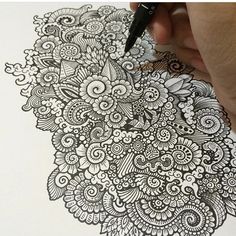 someone is drawing on paper with a pen