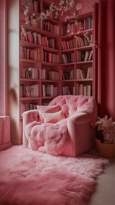 a pink couch in front of a bookshelf filled with lots of bookcases