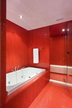 a red tiled bathroom with a bathtub and shower