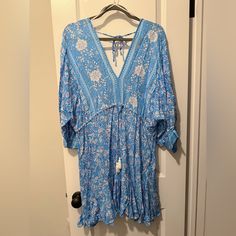 Never Worn, But No Tags Blue Floral Dress Ruffle Hem Drawstring With Tassels Right Under Bust Perfect Beach Cover Up! Blue V-neck Boho Dress For Spring, Blue Long Sleeve Beach Dress For Spring, Blue Summer Tunic Dress, Blue Printed V-neck Beach Dress, Blue Flowy Tunic Boho Dress, Blue Tunic Summer Dress, Blue Flowy Boho Tunic Dress, Casual Blue Midi Dress With Boho Print, Blue Tunic Dresses For Day Out