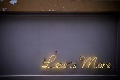 a neon sign that says less is more