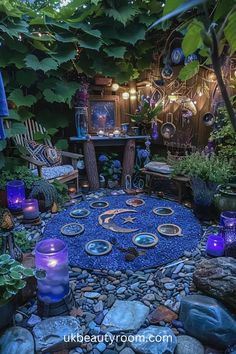 a garden with rocks, plants and candles in the center is lit up by blue lights