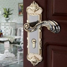 an ornate door handle on a wooden door in a room with white chairs and tables