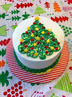 a decorated cake sitting on top of a red and white table cloth covered in green frosting