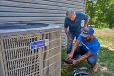 two men working on an air conditioner outside