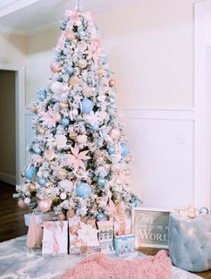 a pink and blue christmas tree with presents under it