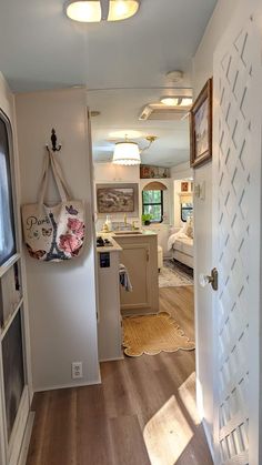 an open door leading to a kitchen and living room in a home with wood flooring