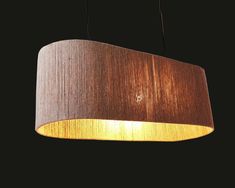 a wooden lamp hanging from the ceiling with a light on it's side and a black background