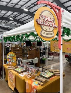 the inside of a store with tables and signs on display for sale in front of it