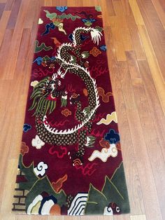 a red rug with a dragon on it in the middle of a wood flooring area