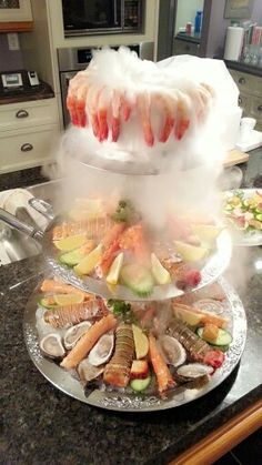 an assortment of seafood on a platter in the middle of a kitchen counter top