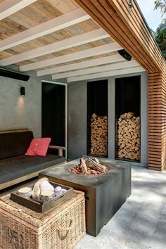 an outdoor living area with couches and firewood