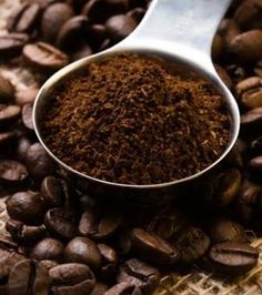 a spoon filled with coffee beans and ground