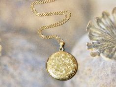 This gold circle locket necklace is a great keepsake necklace. It opens for your favorite two photographs. You will need to find a photo that fits and glue it into place. We do not place the photo in for you and at this time we do not engrave. Its the perfect gift for all agesI T E M • DETAIL:- PENDANT SIZE: Outside measurements 1" round, Inside measurement 3/4" round- CHAIN LENGTH: 16" Delicate Gold Link ChainC A R E • T I P S:We don’t want your special moment to fade. To maintain the quality o