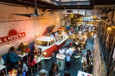 people are sitting at tables and eating in an indoor restaurant with vw vans on the walls