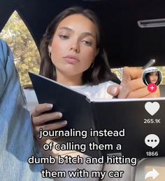 a woman sitting in the back seat of a car while holding a clipboard and writing