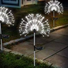 three lighted dandelions in front of a house