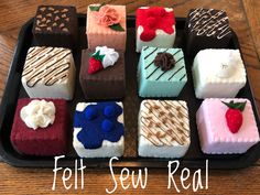 a tray filled with different colored desserts on top of a wooden table and the words felt sew real