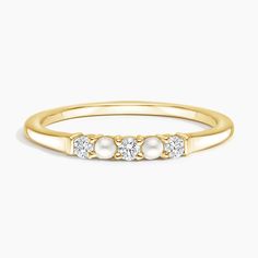 a yellow gold ring with three stones on the top and two diamonds in the middle