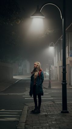 a woman standing in the street at night