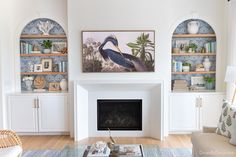 a living room filled with furniture and a fire place in front of a wall mounted painting