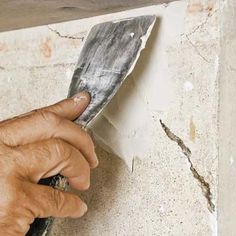 a man is holding a piece of paper in his hand while working on a wall