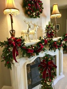 a fireplace decorated for christmas with red bows and deer decorations on it's mantle