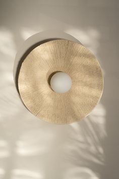 a circular light fixture on a white wall