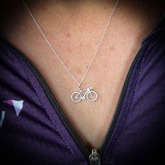 a woman wearing a necklace with a bike on it