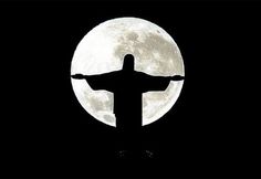 the silhouette of christ in front of a full moon