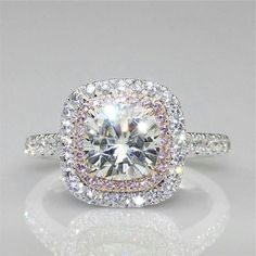 an engagement ring with two rows of diamonds on the band and a center diamond in the middle